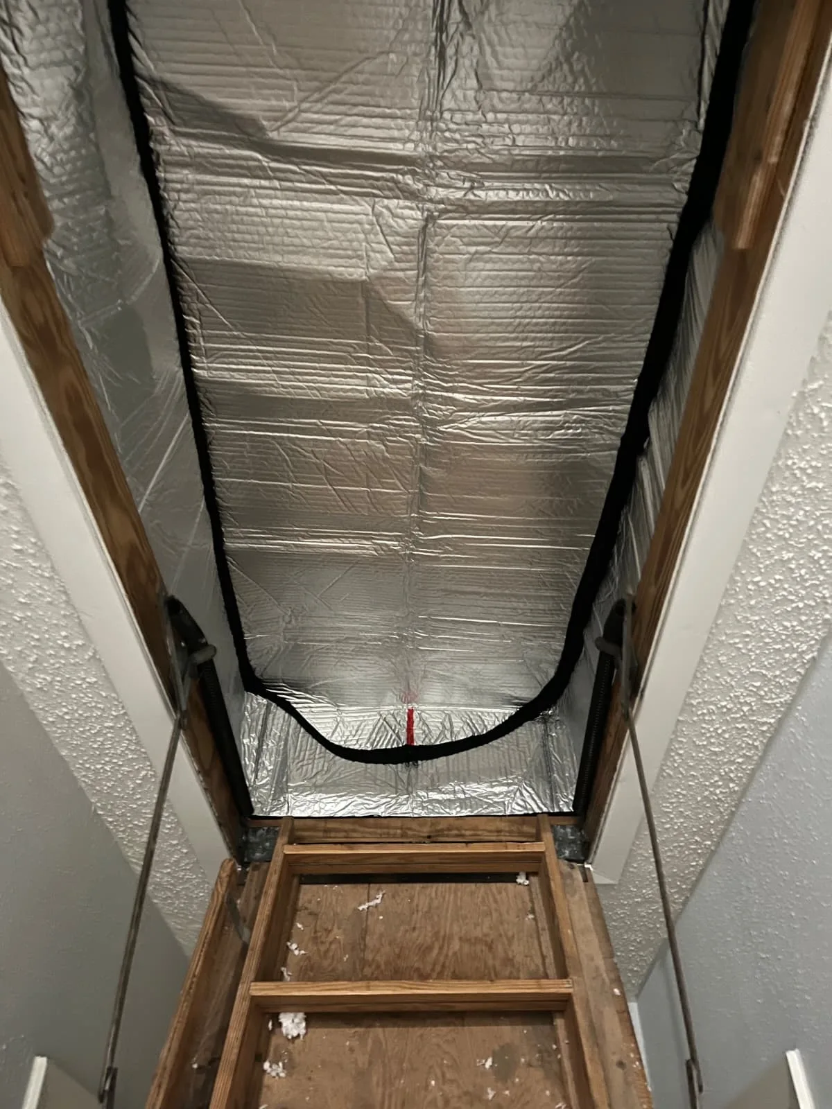 Insulated attic hatch cover for air sealing in a Houston-area home
