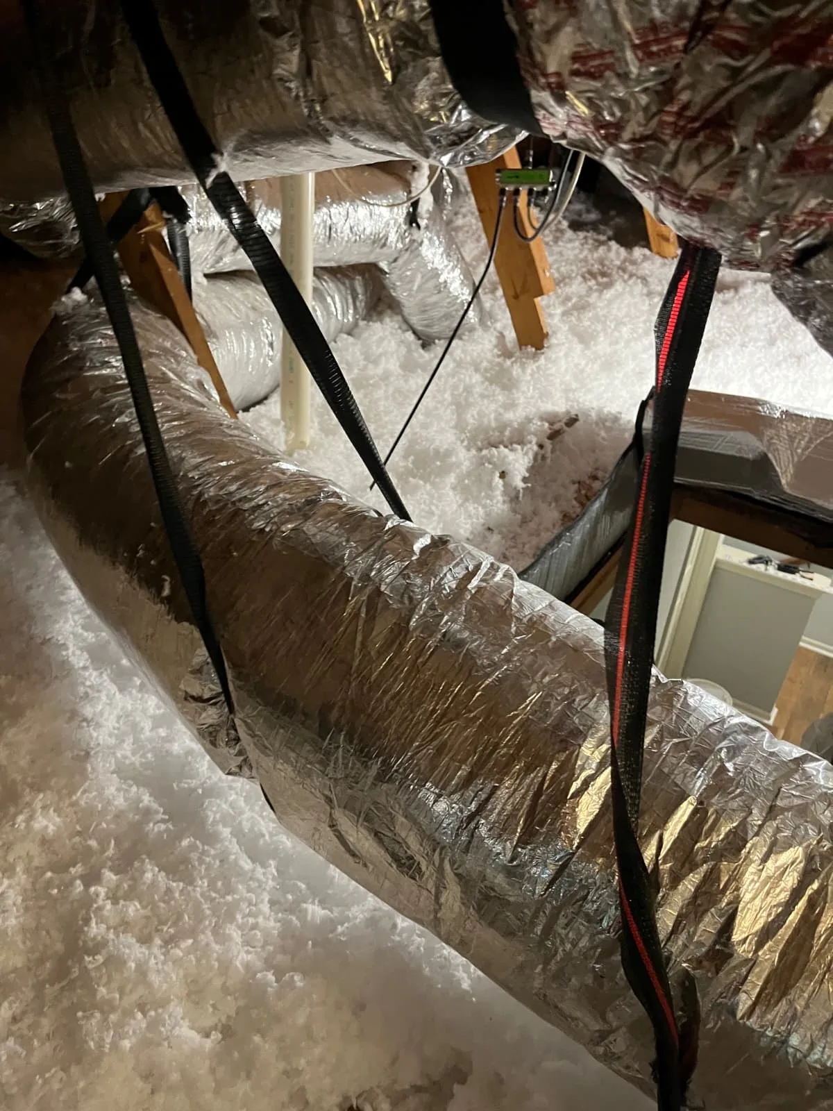 Blown-in insulation covering attic ductwork in a Houston home