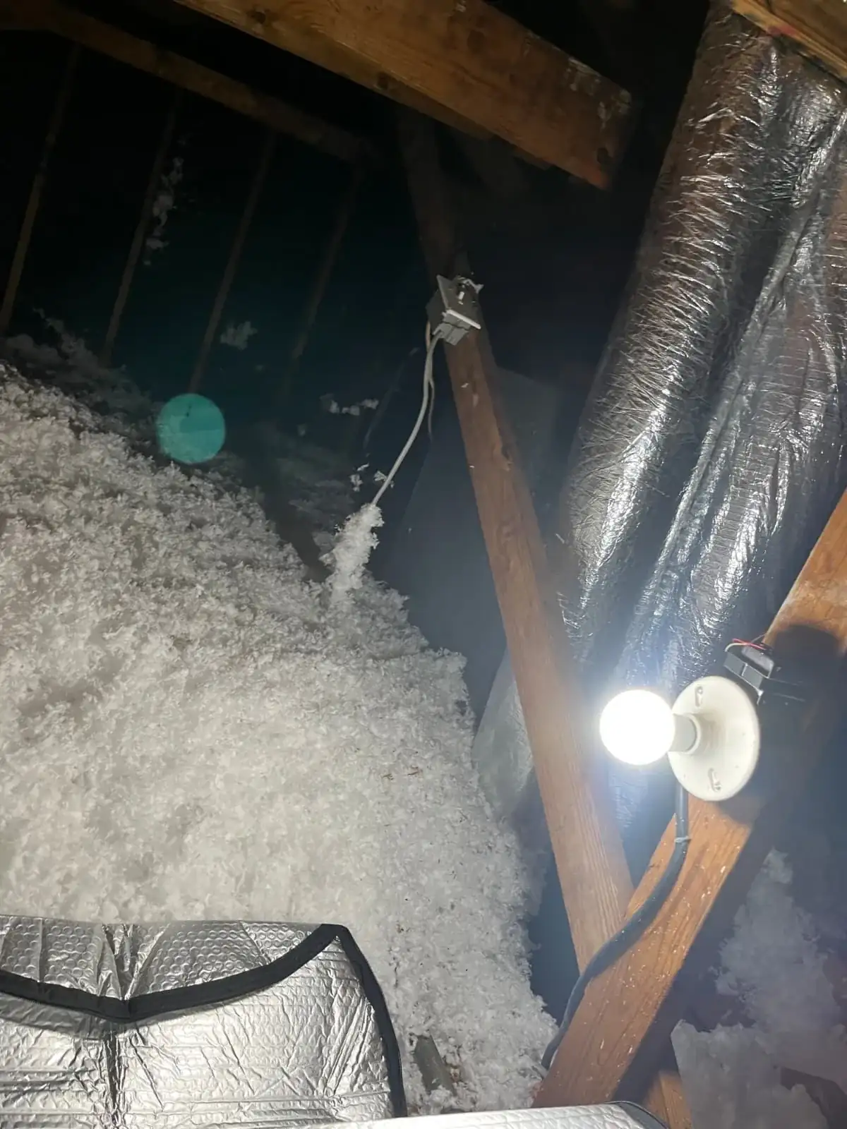 Real job photo: Blown-in attic insulation depth check around ductwork