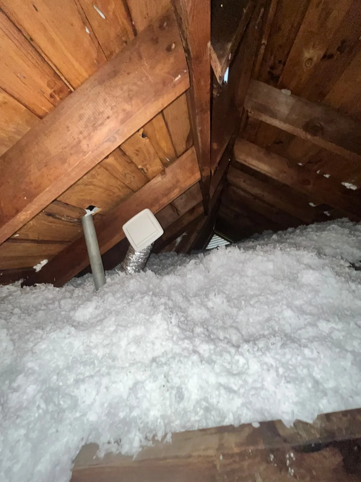 Finished blown-in attic insulation around ductwork and joists in Greater Houston