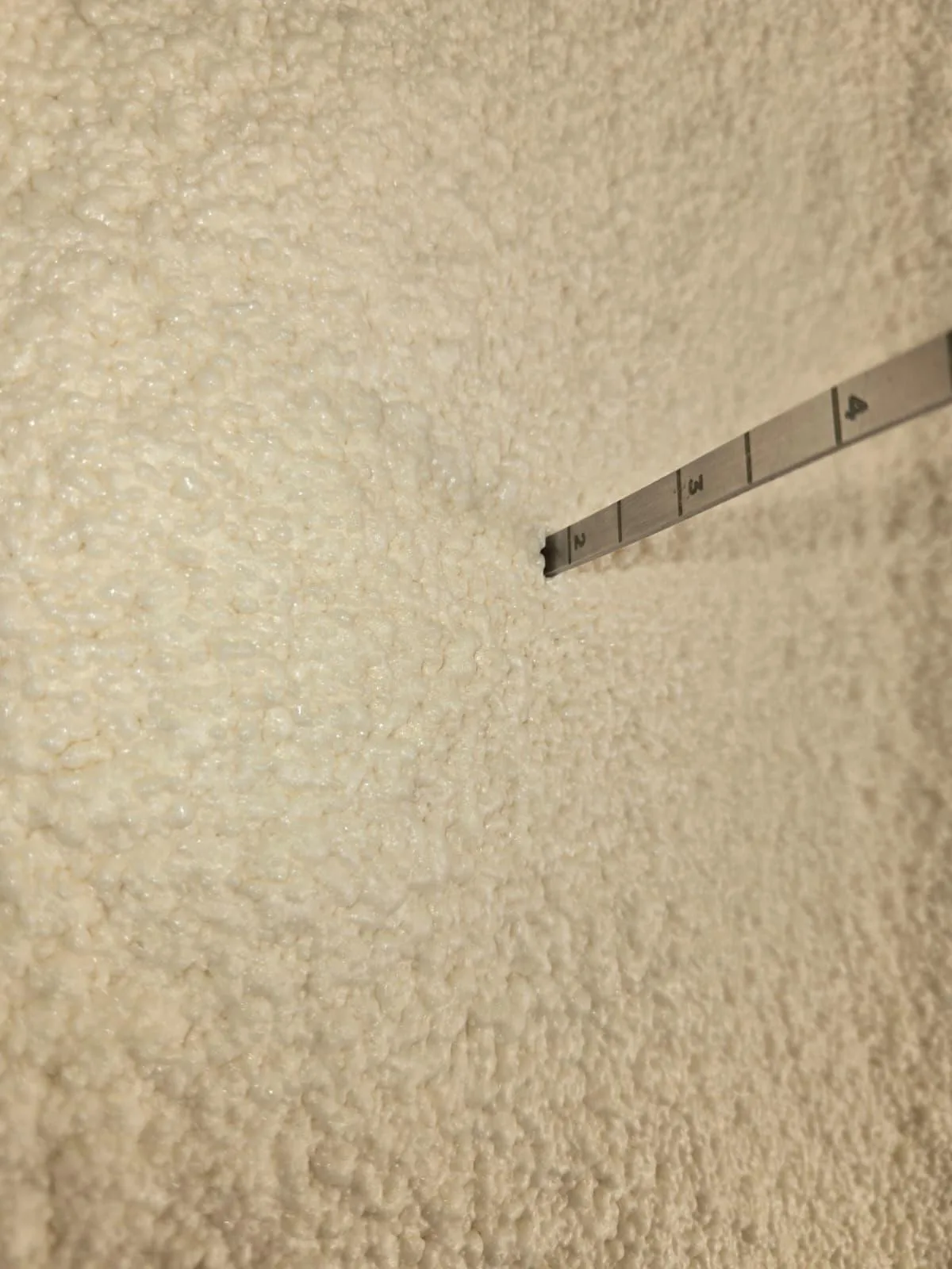 Technician measuring spray foam insulation depth in a Houston attic
