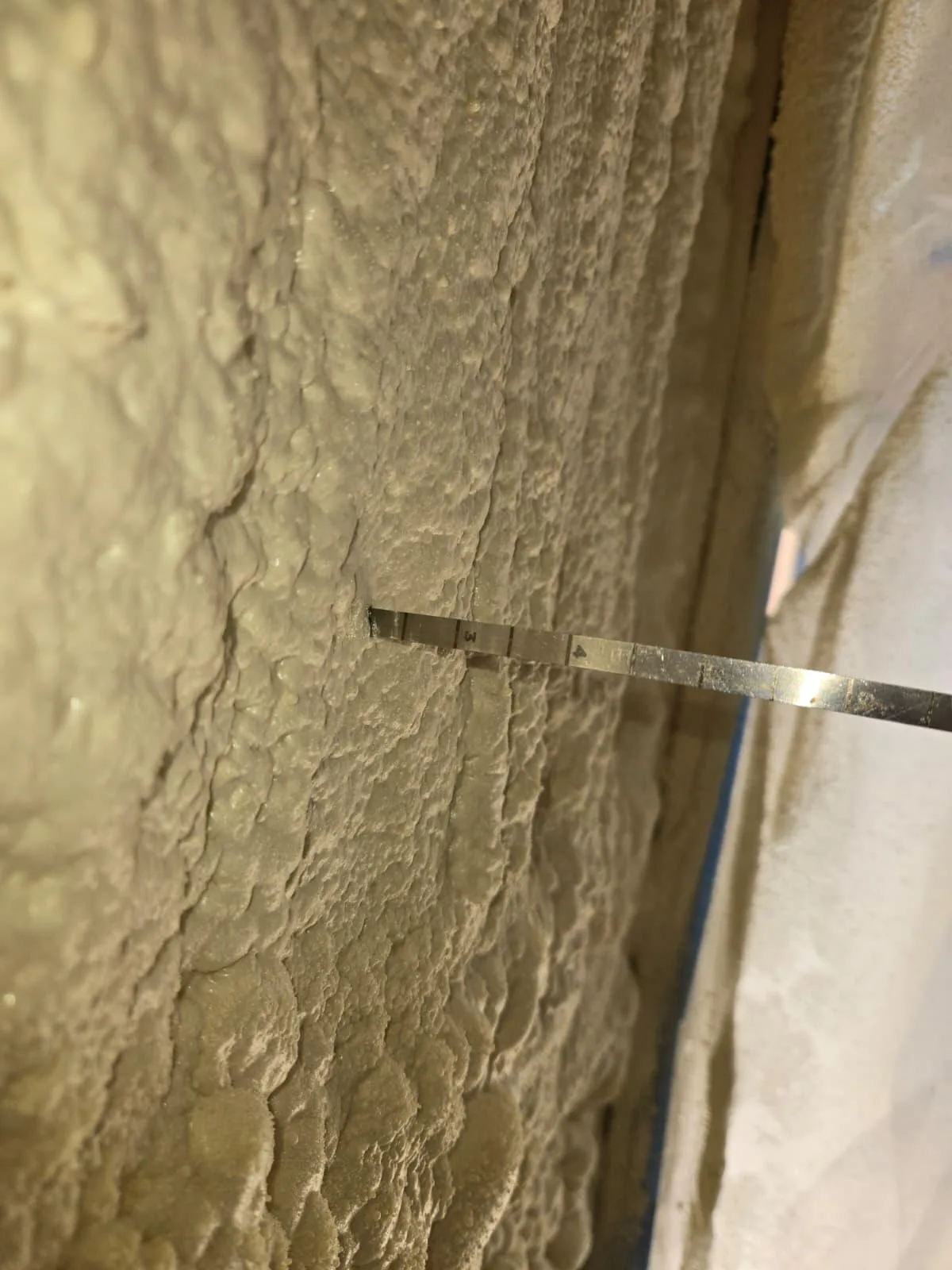 Measuring installed spray foam depth for quality control in a Houston home